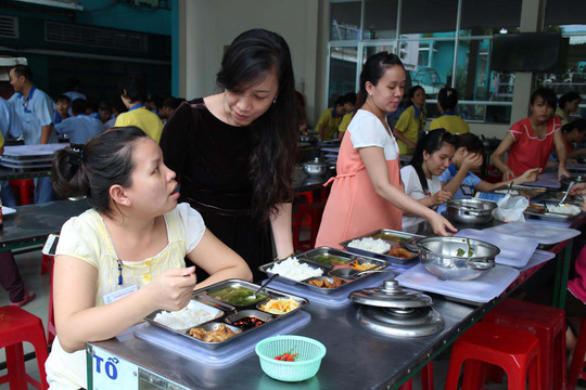Bà Nguyễn Thị Hồng Liên, Chủ tịch Công đoàn Công ty CP SXTM May Sài Gòn, quan tâm đến bữa ăn giữa ca của công nhân Ảnh: Hồng Đào